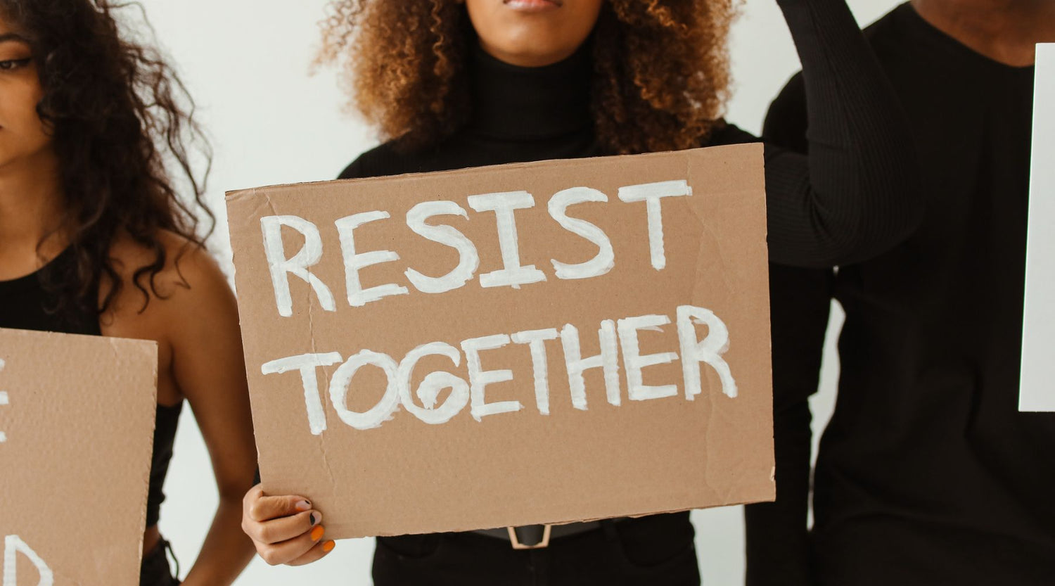 Woman holding sign saying RESIST TOGETHER